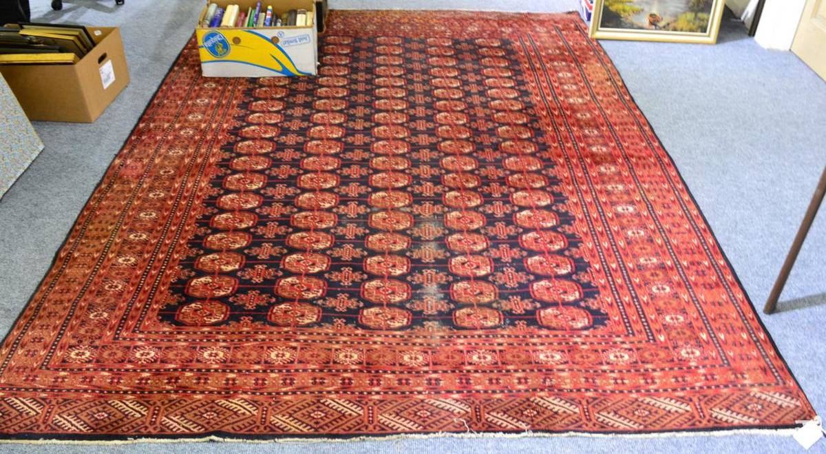 Lot 1104 - Tekke design rug, probably Lahore, Punjab, indigo field with five columns of quartered guls...
