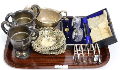 Lot 13 - A group of silver items comprising: two similar twin handled cups, a sauceboat, a cased pair of...