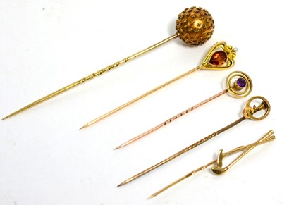Lot 63 - A citrine and seed pearl stickpin, stamped '14K', an amethyst stick pin, a golfing stick pin...