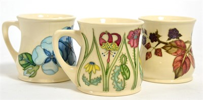 Lot 114 - Moorcroft pottery: a group of three mugs including Centenary by Rachel Bishop (boxed), Tudor...