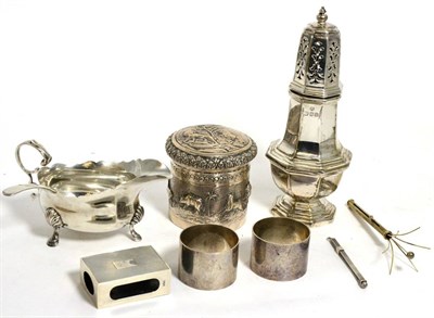 Lot 197 - A collection of silver including sauceboat, caster, napkin rings, matchbox holder etc