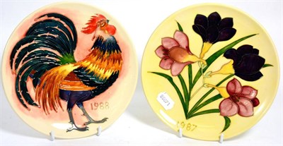 Lot 322 - Moorcroft pottery: two plates, Freesia 1987 year plate, no. 182/250, designed by Walter...