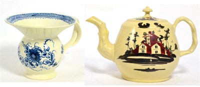 Lot 326 - Creamware teapot decorated with a landscape together with a creamware blue and white cup (2)