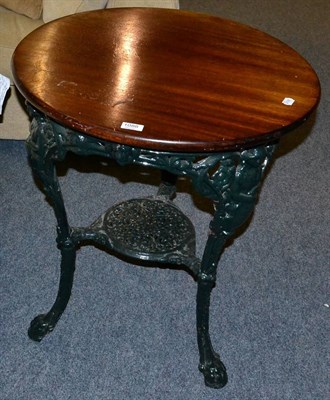 Lot 1088 - A green painted cast iron circular table with later wood top