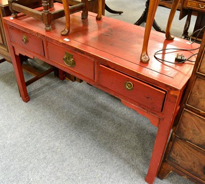 Lot 1125 - A Chinese red softwood three drawer table