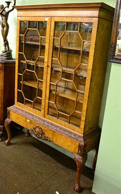 Lot 1209 - A walnut glazed bookcase on stand