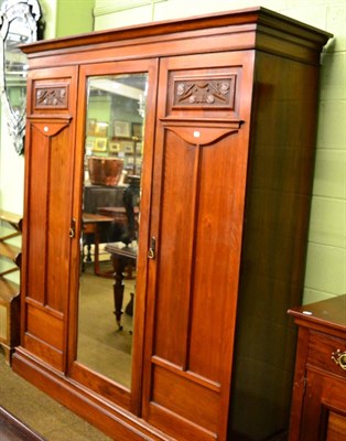 Lot 1334 - A three section wardrobe with fitted interior and art nouveau style detailing