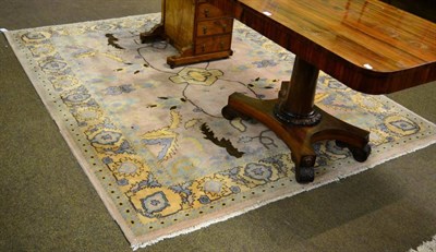 Lot 1358 - An Indian carpet, the field sparsely decorated with serrated leaves enclosed by floral borders,...