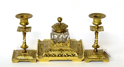 Lot 220 - A three piece gilt brass desk set comprising inkwell with a pair of candlesticks (3)