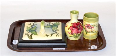 Lot 223 - Two Moorcroft pottery Hibiscus miniature vases, together with a Moorcroft cover