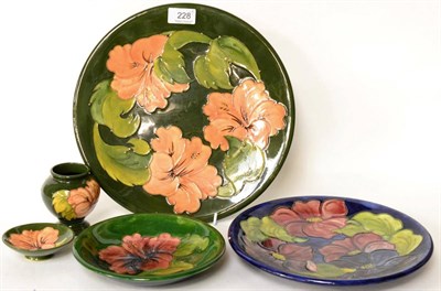 Lot 228 - Five pieces of Walter Moorcroft pottery including coral Hibiscus, Clematis, and standard...