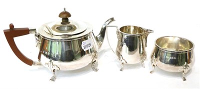 Lot 484 - A three piece silver tea service, Adie Bros, Birmingham 1923, with foliate capped stepped hoof...