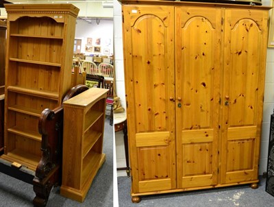 Lot 1088 - A modern pine triple door wardrobe and two pine open bookcases (3)