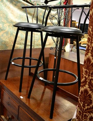 Lot 1091 - A pair of black lacquer bar stools and two coat stands (4)