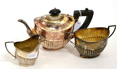 Lot 137 - A silver three piece tea set with part gadrooned body comprising teapot, cream and sugar each...