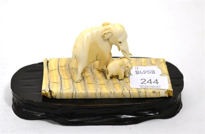 Lot 244 - A 19th century carved ivory elephant and calf mounted on elephant tooth