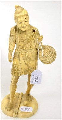 Lot 284 - A Japanese Meiji period ivory okimono of a market seller