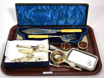 Lot 300 - A cased silver fish server, silver mounted hand mirror, three silver napkin rings, silver strainer