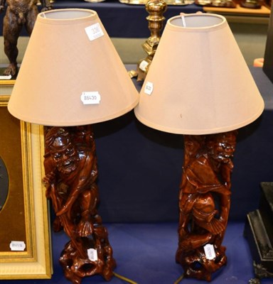 Lot 336 - A pair of Chinese carved hardwood figural table lamps