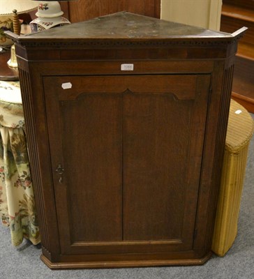 Lot 1068 - A George III oak corner cupboard