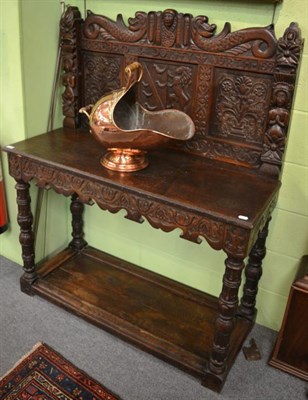 Lot 1216 - A carved oak table with panel back