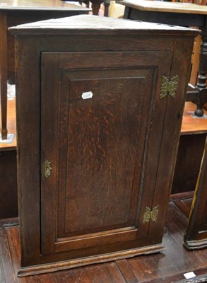 Lot 1313 - A Georgian oak hanging corner cupboard