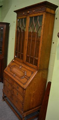 Lot 1334 - A glass fronted oak bureau bookcase together with an oak and glass desk standish