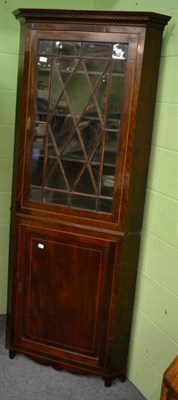 Lot 1335 - A George III mahogany freestanding corner cupboard, astragal glazed door