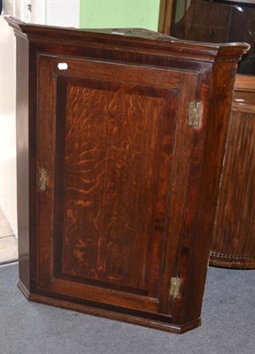 Lot 1338 - A Georgian cross banded oak hanging corner cupboard