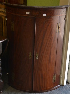 Lot 1339 - A Georgian inlaid mahogany bow fronted hanging corner cupboard