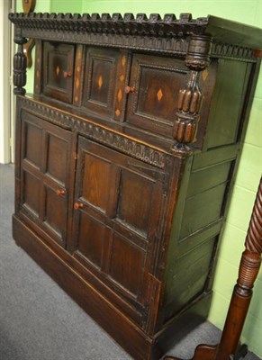 Lot 1344 - A 17th century inlaid oak court cupboard, the castellated cornice above two inlaid panelled...