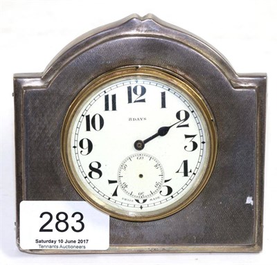 Lot 283 - A silver mounted easel backed timepiece, Sheffield 1931, with engine turned decoration, 11cm...