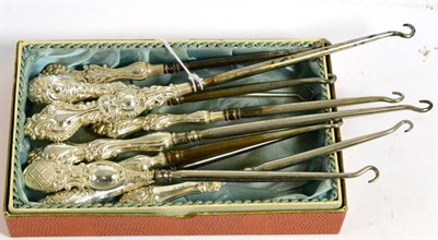 Lot 358 - Ten assorted silver mounted button hooks, each with rococo style C scroll decoration to the...