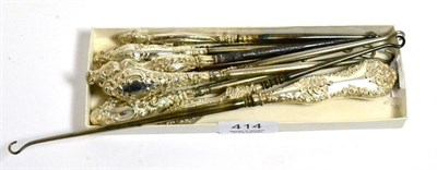 Lot 414 - Ten assorted silver mounted button hooks, each with rococo style C scroll decoration to the...