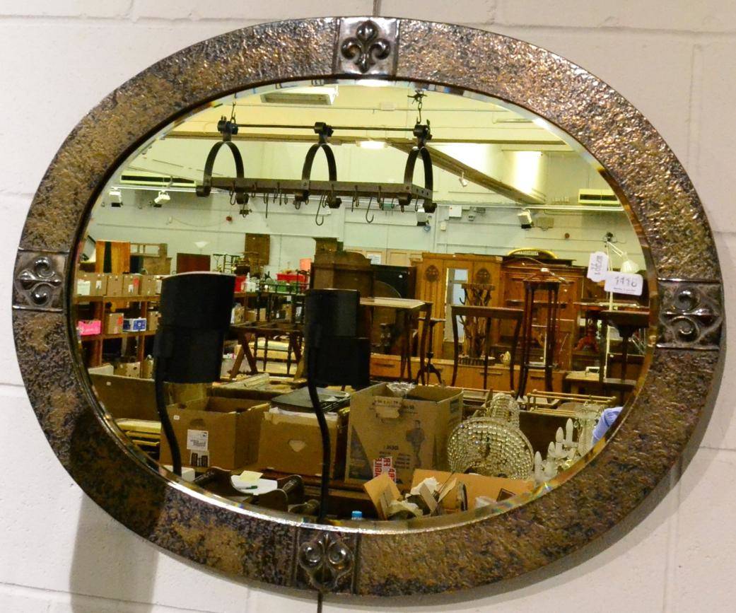 Lot 1118 - Arts & Crafts oval bevel glass mirror with hammered metal frame