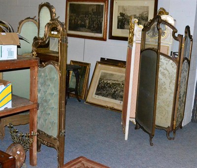 Lot 1163 - A gilt, upholstered and mirrored four fold screen together with two further three fold screens