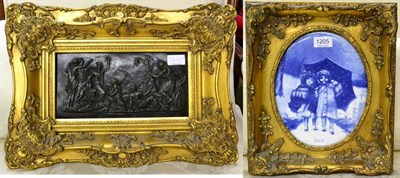 Lot 1205 - A bronze relief plaque, framed; and a blue and white transfer printed porcelain plaque (2)