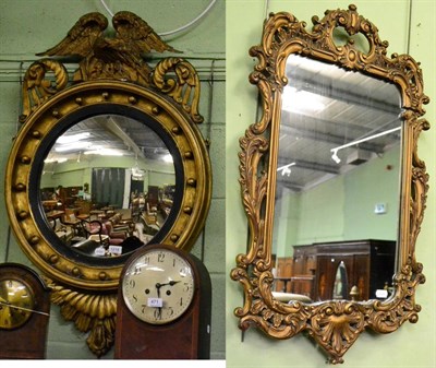 Lot 1218 - A Regency style convex wall mirror with carved eagle surmount; and a modern composition wall mirror