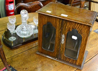 Lot 1275 - An oak smokers cabinet and a Stuart crystal five piece decanter set on stand