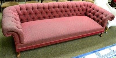 Lot 1298 - A red fabric upholstered Chesterfield sofa with button back on ball and claw supports