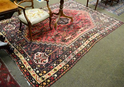 Lot 1312 - Kashgai rug, South West Iran, the raspberry field of tribal devices around a stepped medallion...