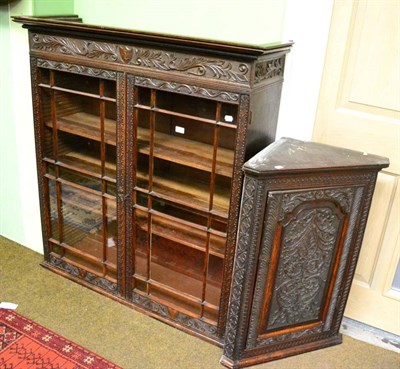 Lot 1340 - A Georgian carved oak corner cupboard and a carved oak glazed bookcase lacking face