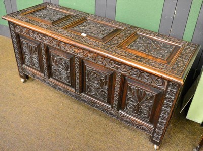 Lot 1349 - A 19th century panelled oak coffer with extensive carved decoration