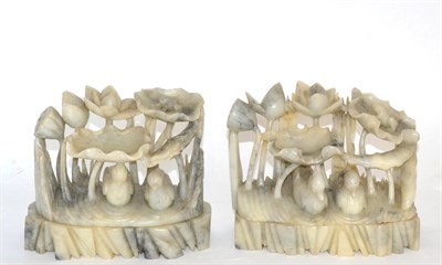 Lot 11 - Two Chinese celadon and black veined carved ornaments, decorated with ducks sheltering beneath...