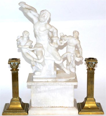 Lot 30 - An alabaster figure group of Laocoön and his sons, a plinth base and two brass candlesticks