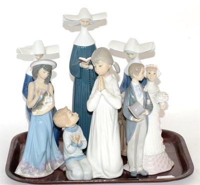 Lot 43 - A group of Lladro figures comprising three nuns, wedding couple, girl and dog, and boy and girl...