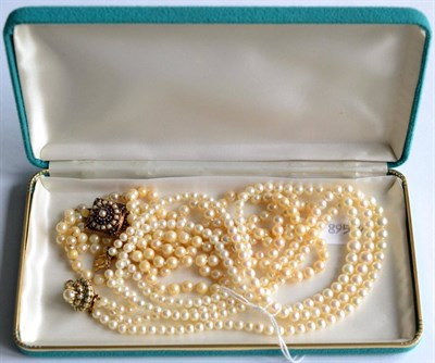 Lot 158 - Two triple strand cultured pearl necklaces with pearl and gem set clasps