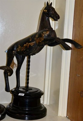 Lot 256 - An antique ebonised wood galloper horse on associated circular plinth