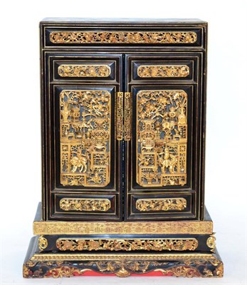 Lot 392 - A Japanese lacquered and gilt cabinet, with ornately pierced and carved relief decoration