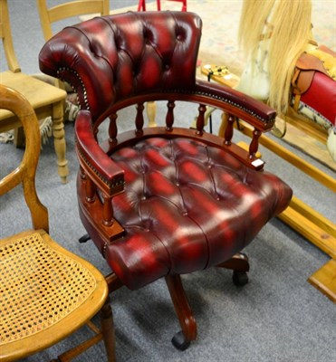 Lot 1196 - A reproduction mahogany and buttoned red leather office chair